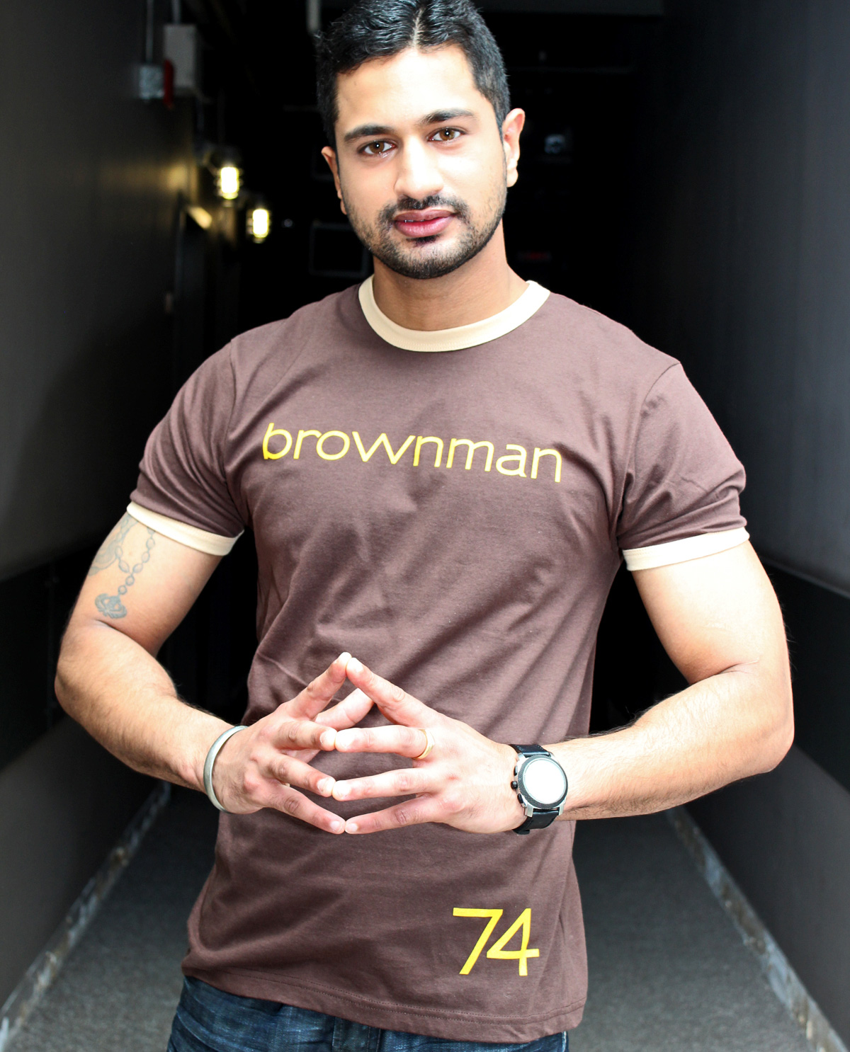 South Asian Male Model wearing American Apparel Brown Ringer T Shirt Graphic Design T.shirt with brownman74 graphic design on front.